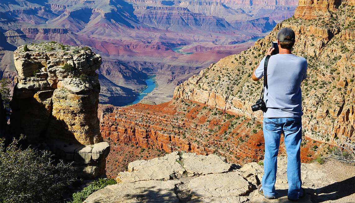 visitor takes a photo of the Grand Canyon
