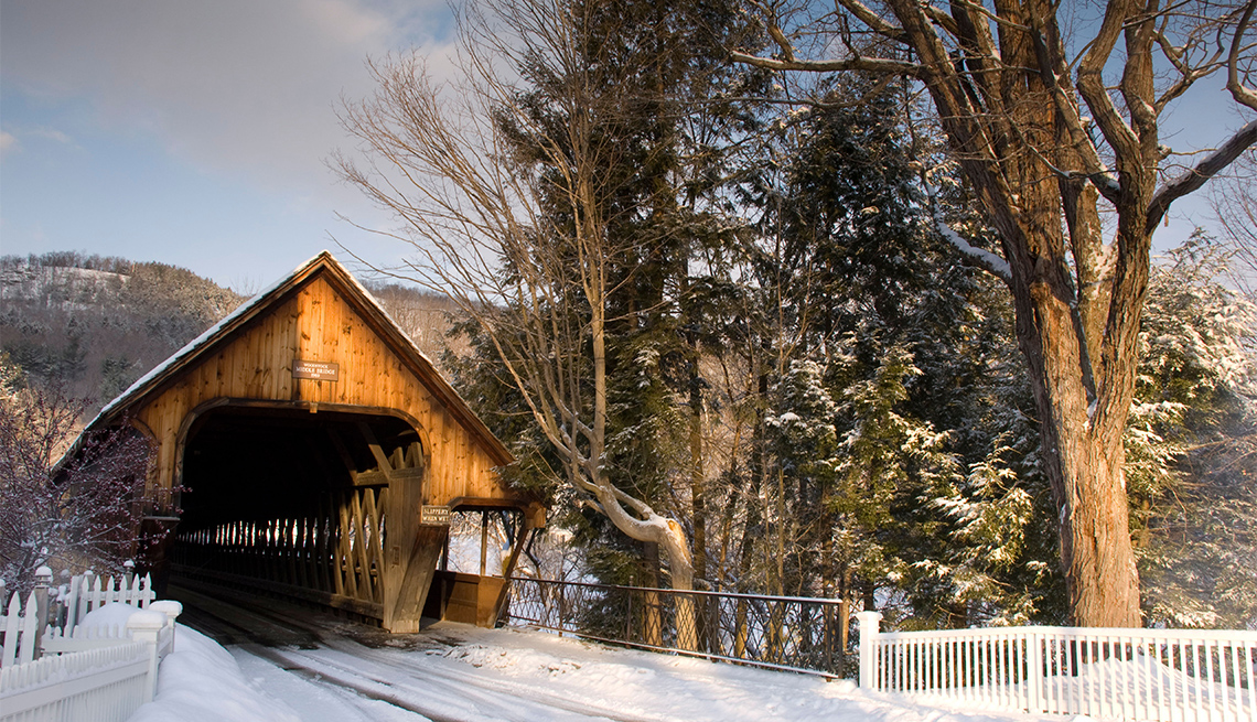 Vista frontal de un puente de madera cubierto en invierno