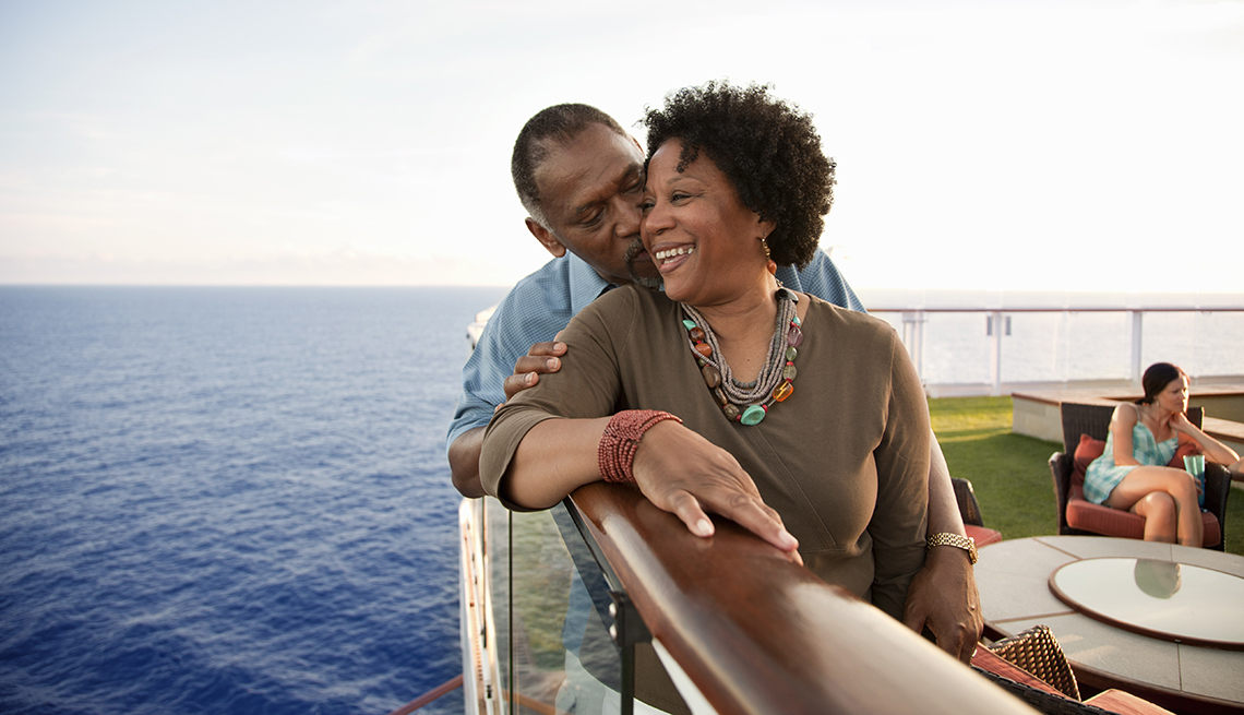 African American Couple Snuggle, Railing of Cruise Ship, Strategies for Scoring Last-Minute Travel Deals