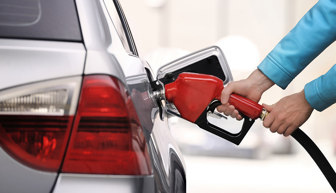 Hands Red Fuel Nozzle, White Car, Tips for Stretching Your Car Rental Dollars