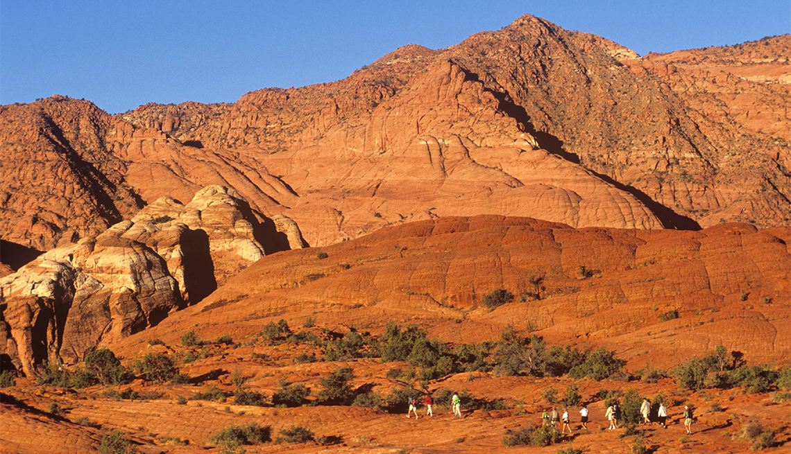 item 3 of Gallery image - Red Rock formations dwarf hikers at Snow Canyon State Park