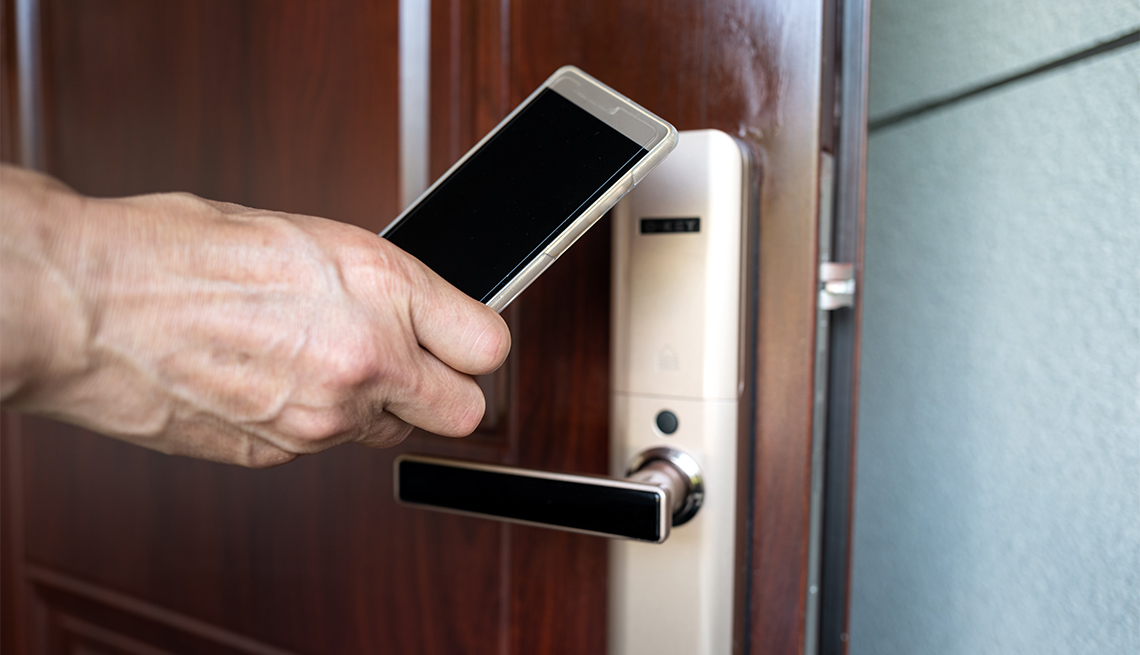 Human hand uses mobile phone to sense hotel room door