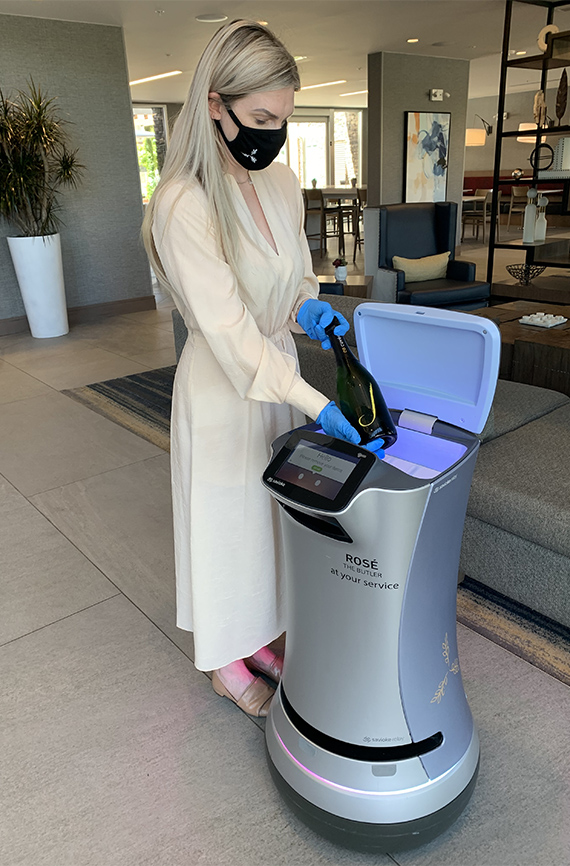 El robot Rosé entrega vino a una mujer en un hotel