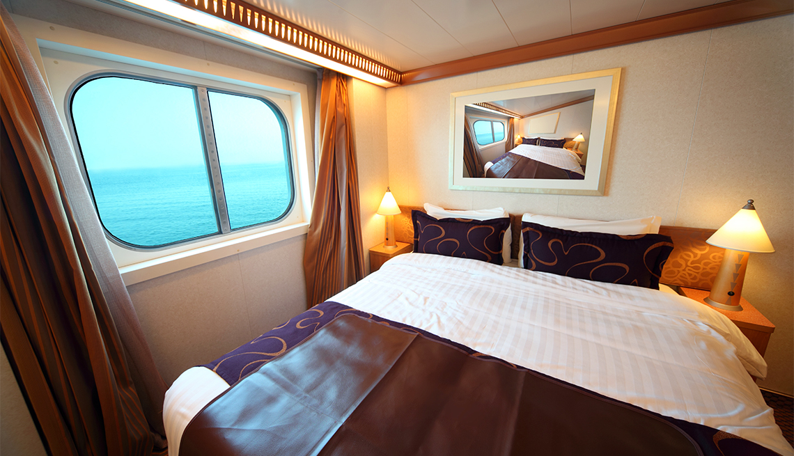 Cabina de un crucero con ventana y cama doble.