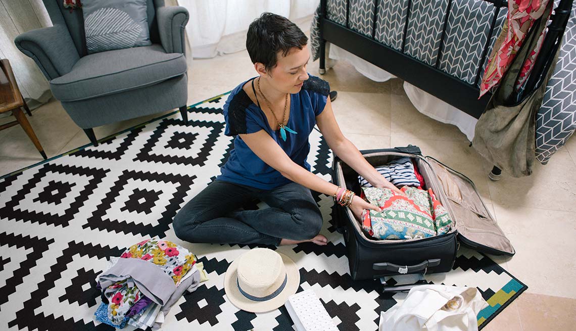 Mujer empacando una maleta de viaje