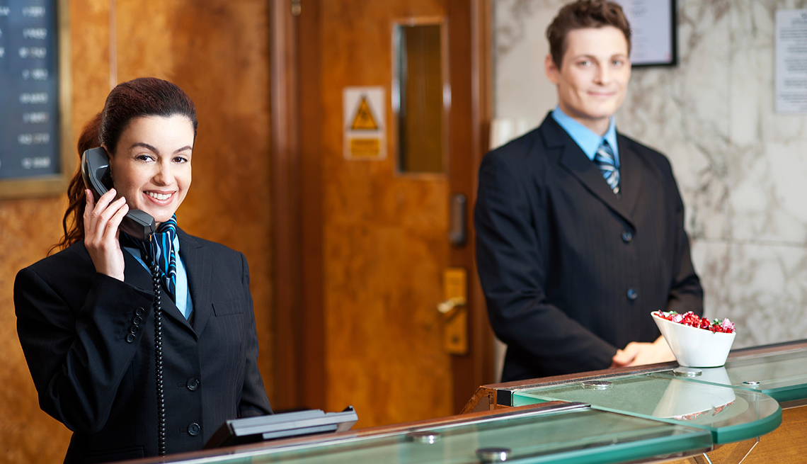 Hotel Employees at Reception Desk, Tips for Stretching Your Hotel Dollars