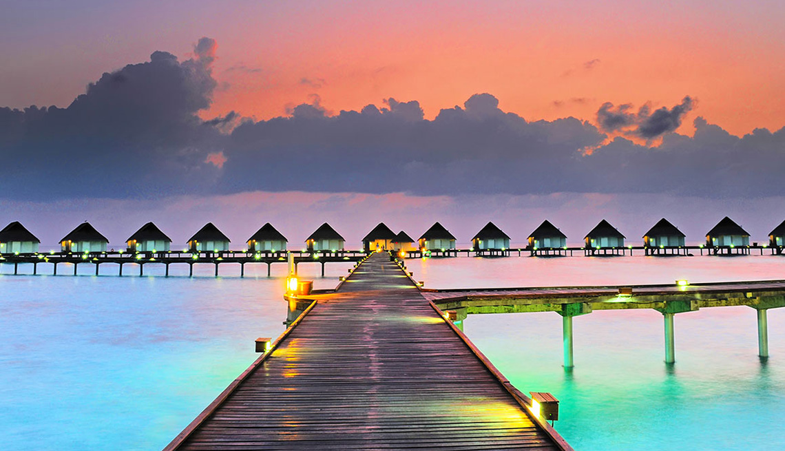 Bungalow Huts Over The Water With Dock In Foreground In Maldives, Best Honeymoon Destinations