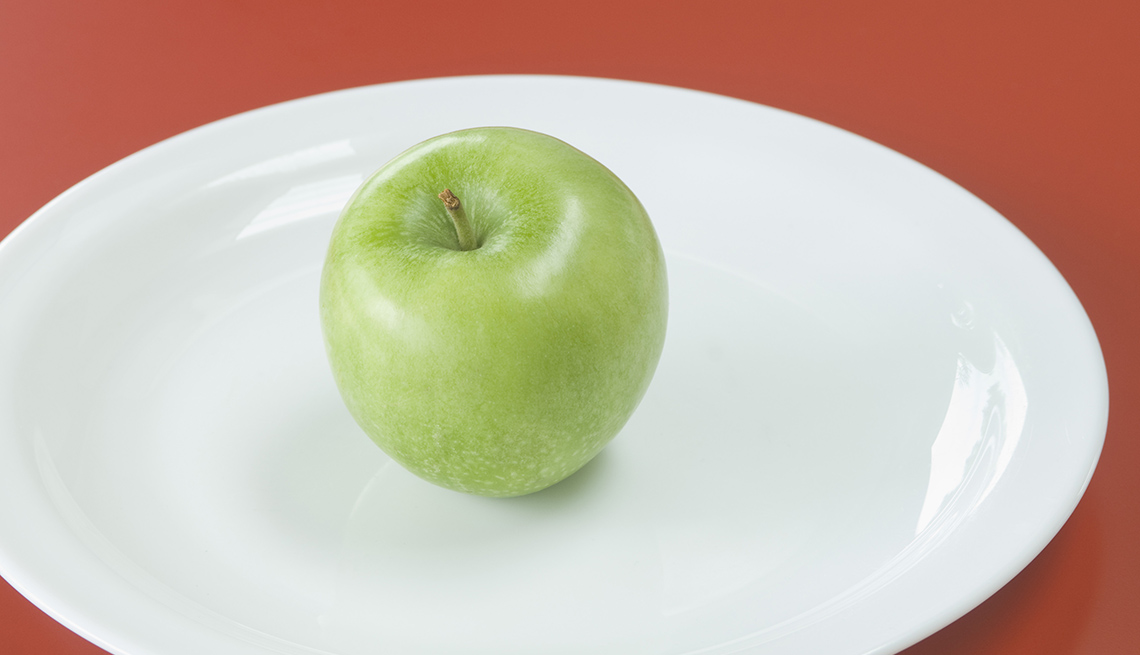 A Green Apple On A White Porcelain Plate, Foods To Avoid Before Flying