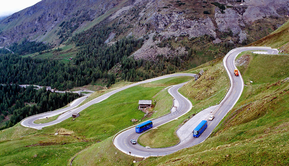 Two Tour Buses On A Narrow Windy Road Through The Mountains, Bus Tour Pros