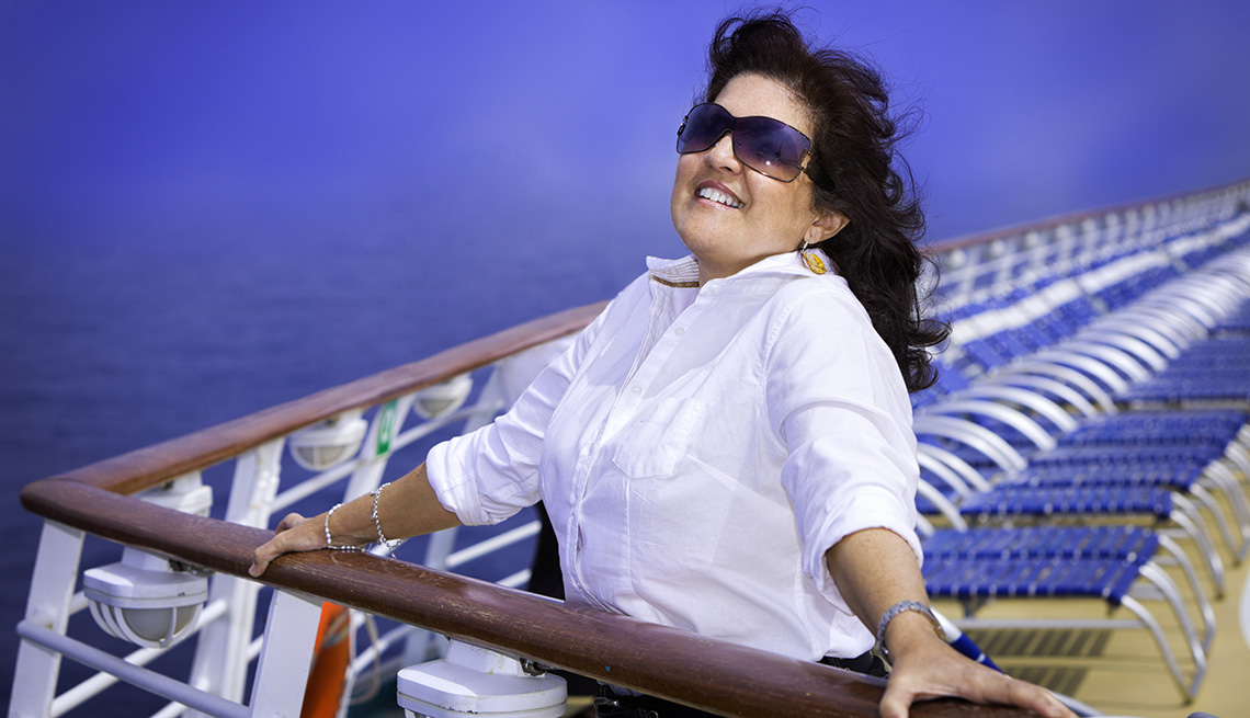 Smiling Caucasian Woman Holds Onto Railing On Ships Deck, Cruise Ship Myths