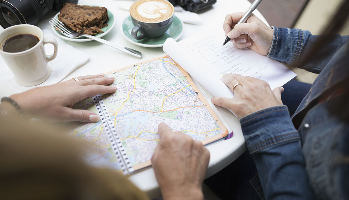 Amigos revisan un mapa mientras toman café.