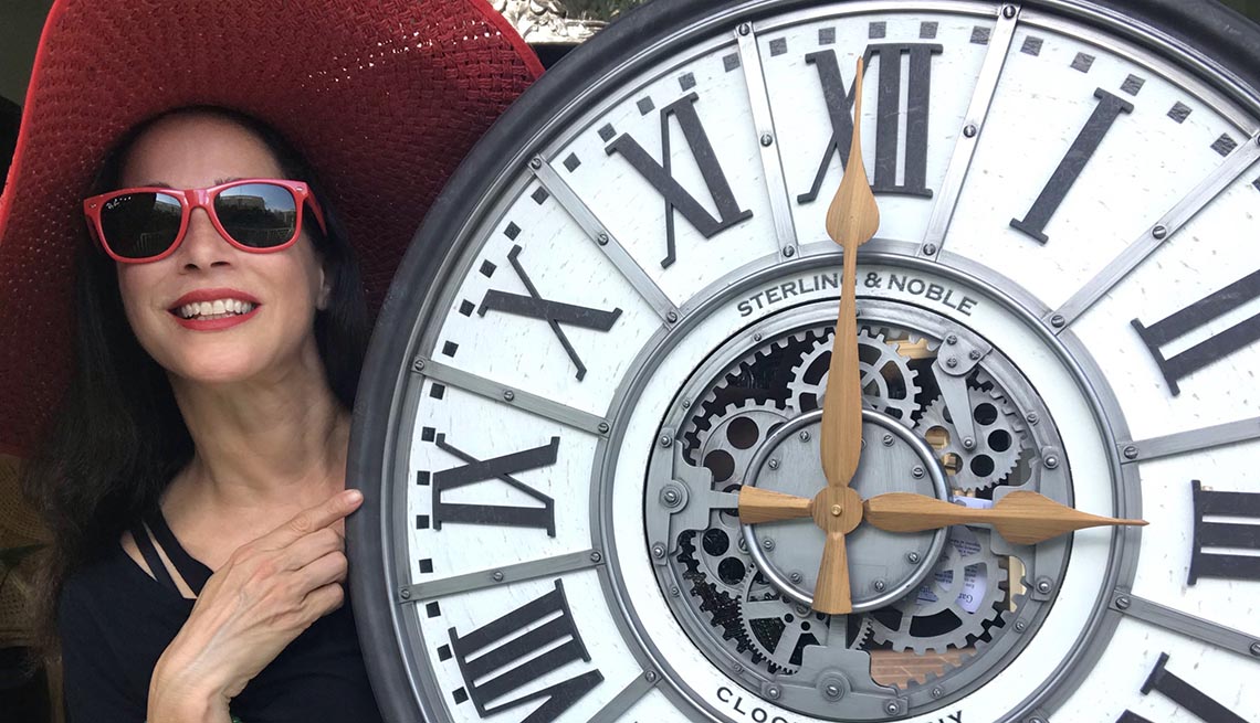 Carmen Dominicci junto a un reloj grande con manecillas