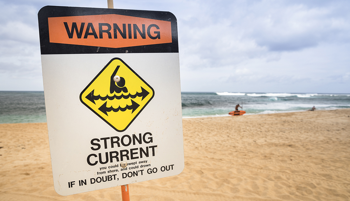 Sign on the beach that reads: Warning: Strong Current. If in doubt, don't go out