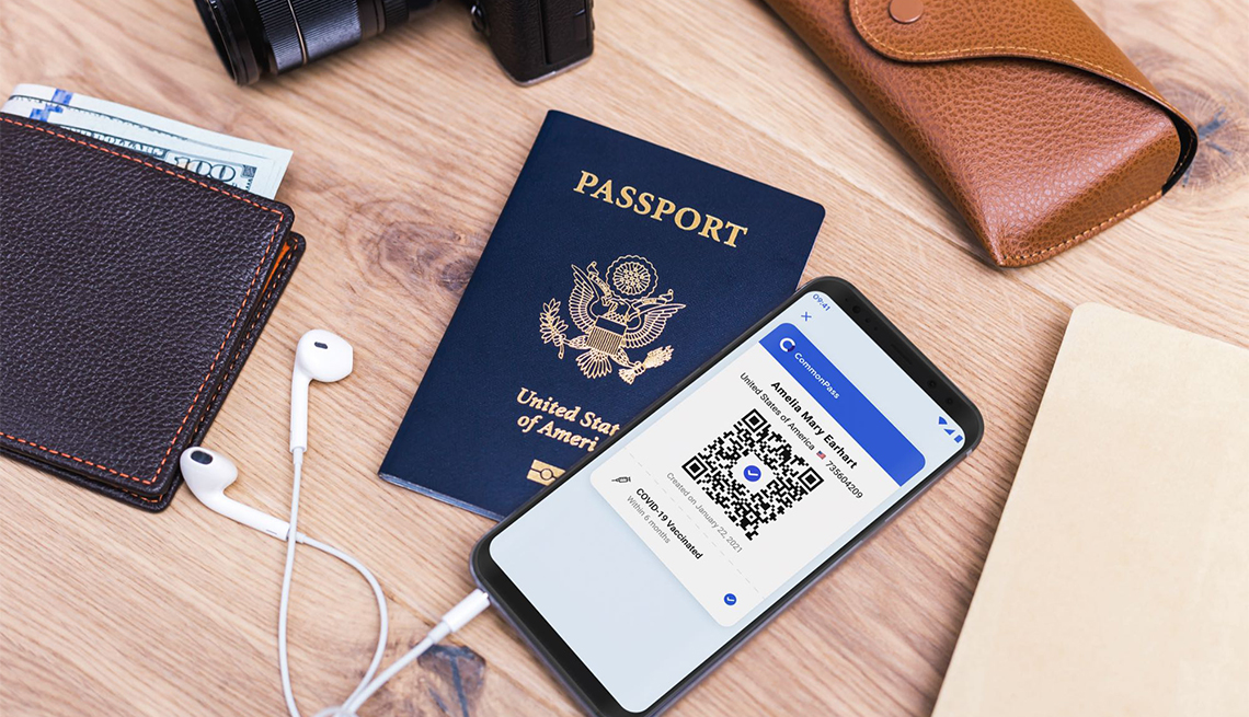 Pasaporte, billetera, lentes y teléfono sobre una mesa
