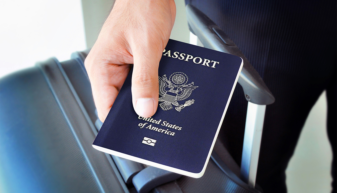 Persona sostiene un pasaporte en la mano
