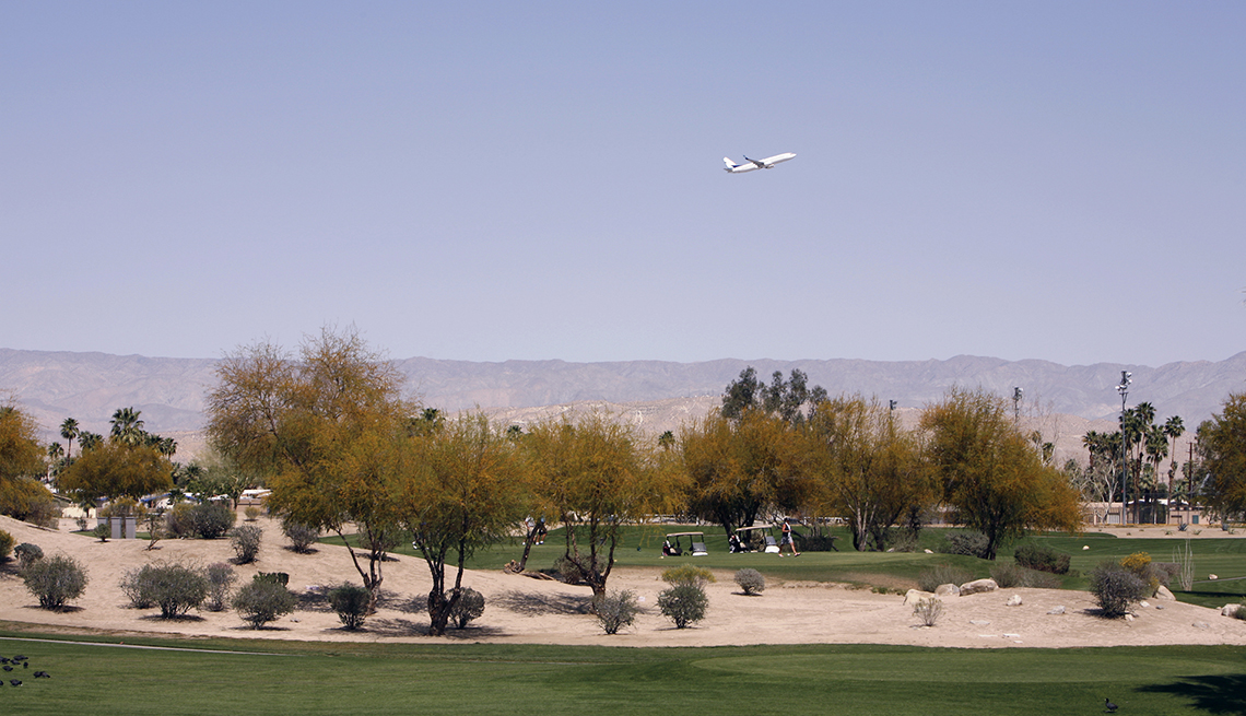 Jet comercial volando sobre un campo de golf