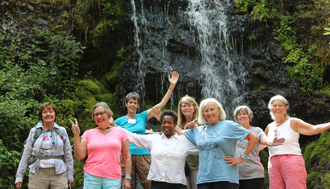 group of women standing in front of waterfall