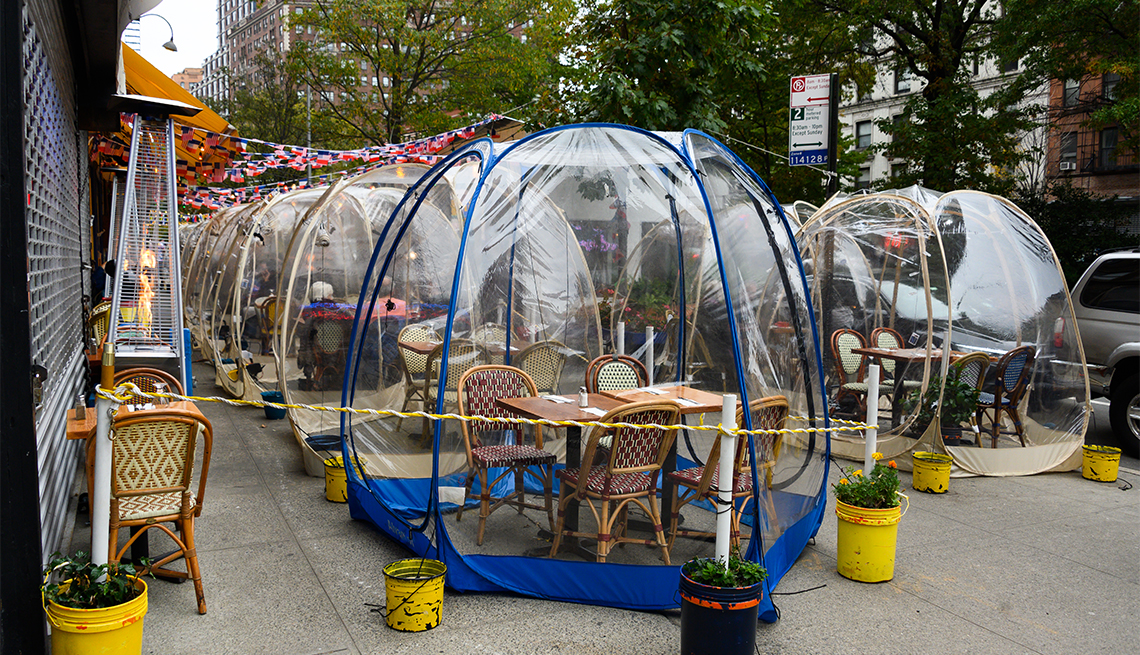 Mesas de un restaurante cubiertas por burbujas de plástico que sirven para mantener el distanciamiento social