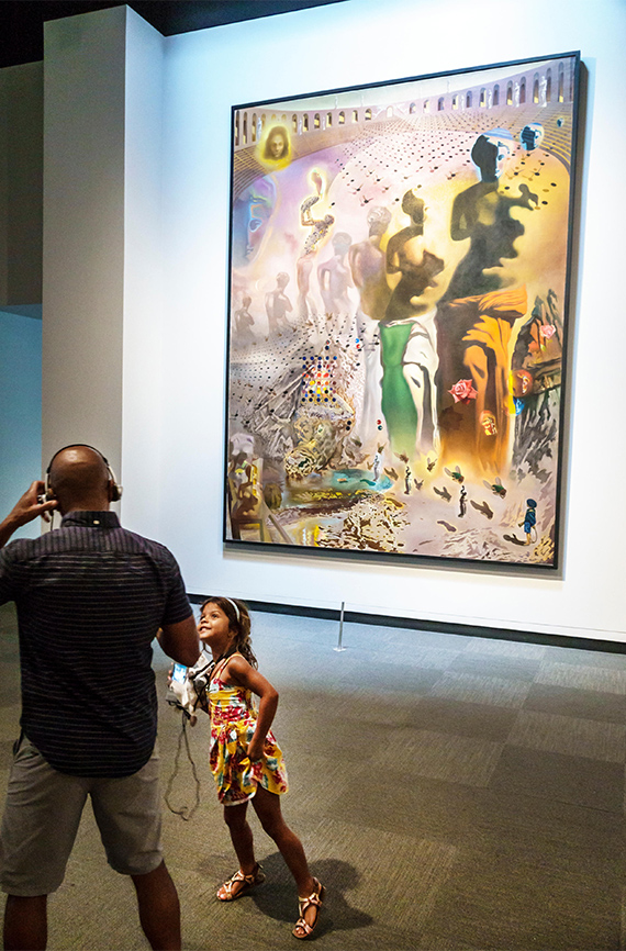 Un hombre con una niña observan una pintura en el Museo Dalí