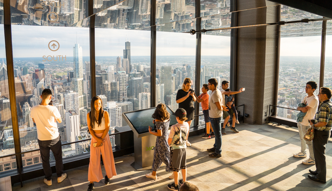 people overlooking chicago and lake michigan from the hancock building