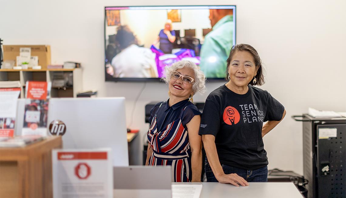 two volunteers standing behind the counter of a senior planet locations