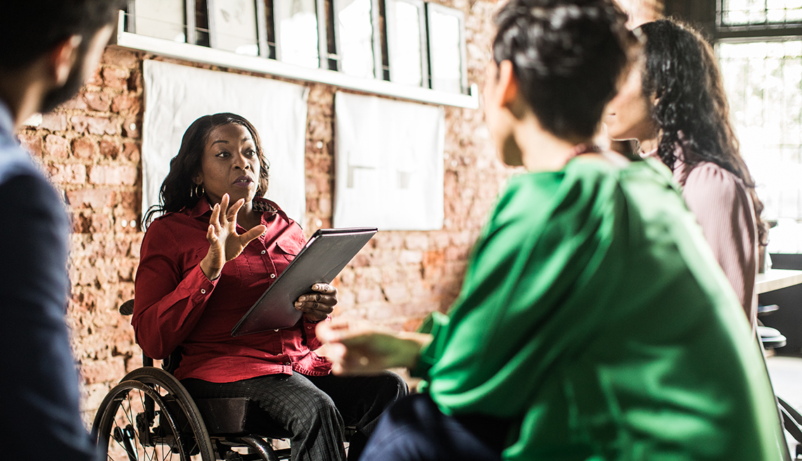 Businesswoman in wheelchair leading a group discussion in an office