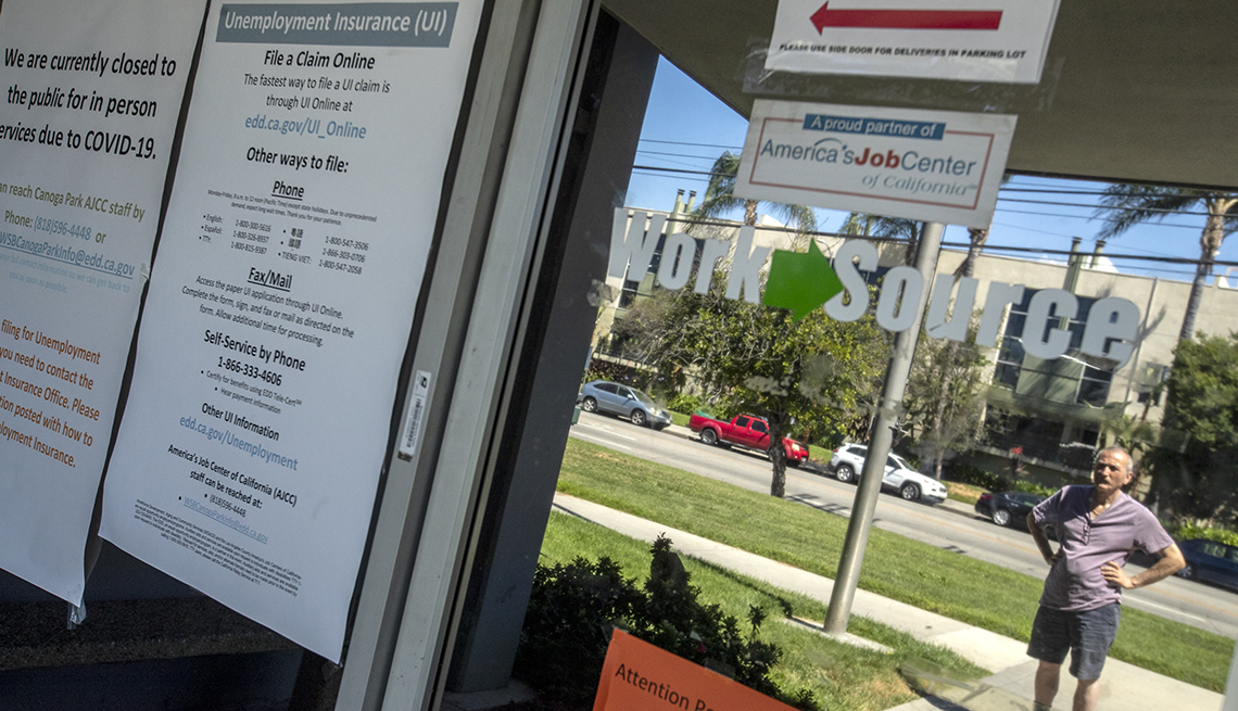 Un hombre lee anuncios en la ventana del Departamento del Desarrollo del Empleo del estado de California, el cual se encuentra cerrado.