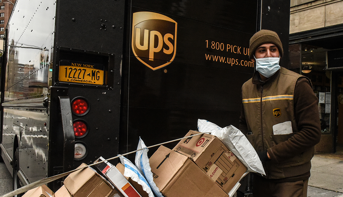 Conductor de UPS con varios paquetes para entregar.