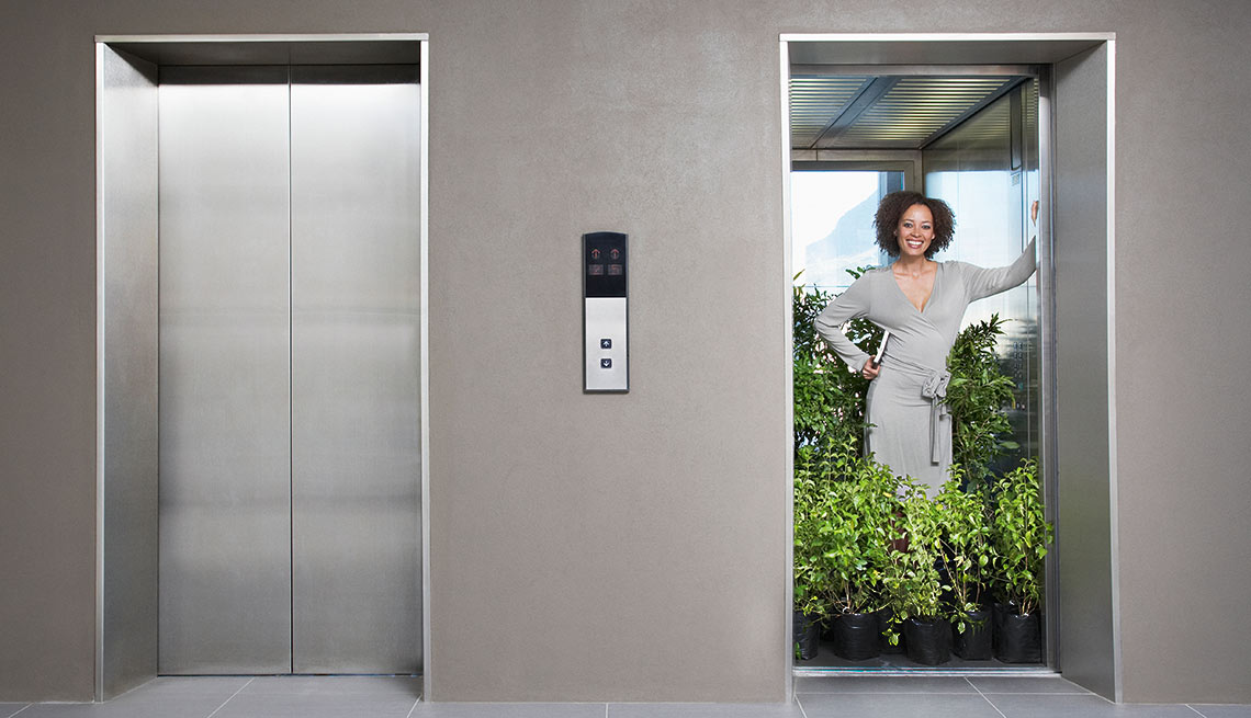 Dos puertas de un elevador, una cerrada y la otra abierta con una mujer rodeada de plantas