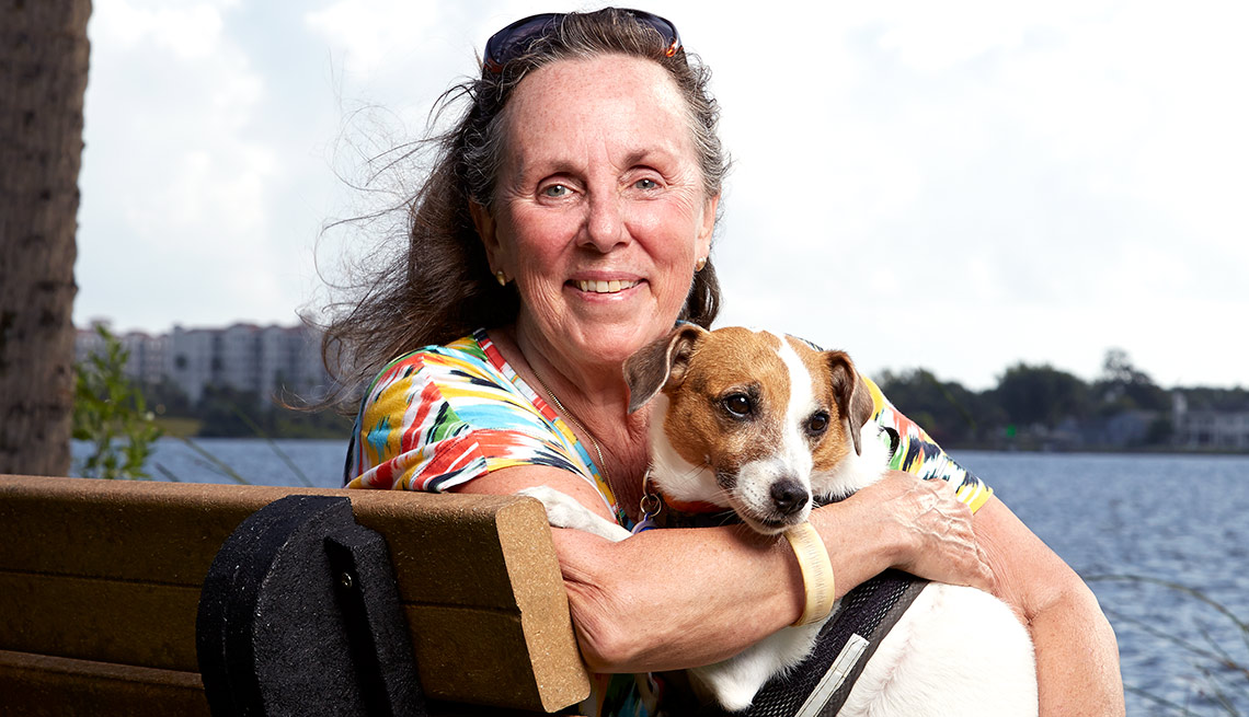Janet Boes sostiene a su perro - Beneficiados con el Seguro Social