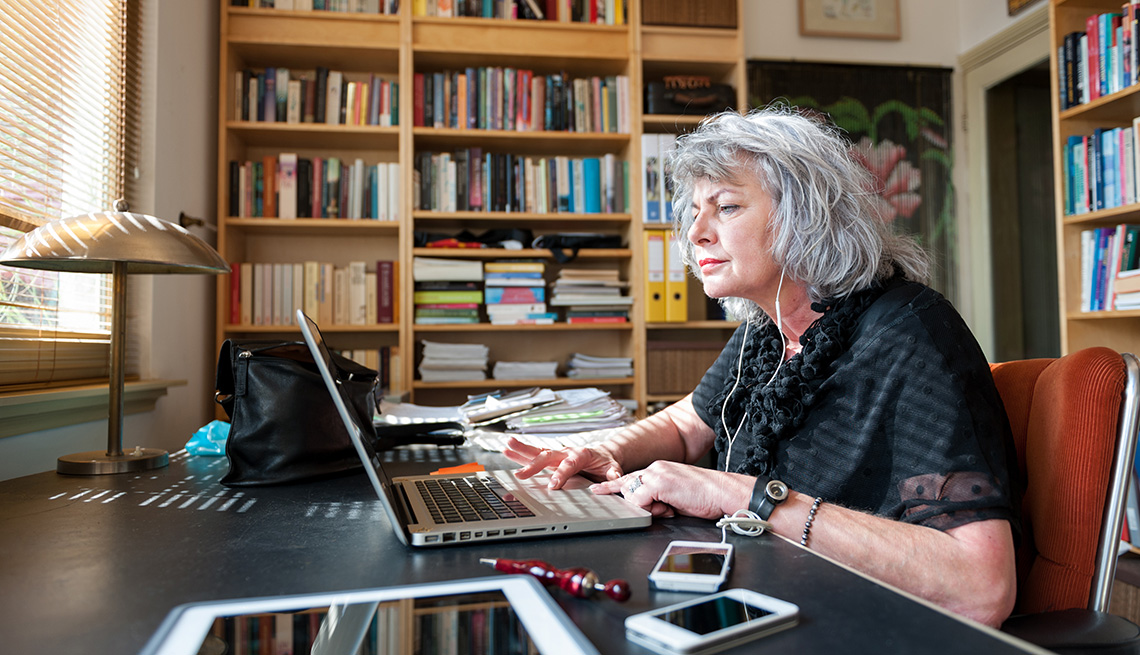 Mujer mayor frente a una computadora personal - Seguro Social y trabajadores independientes.
