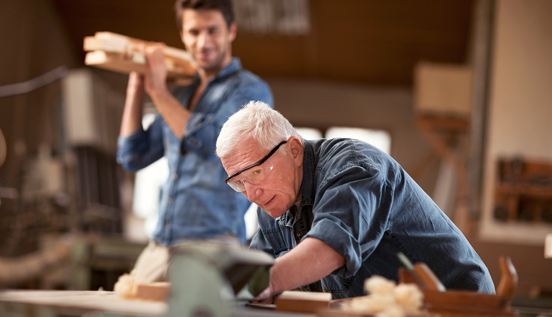 Hombre mayor y hombre joven trabajando en una carpintería
