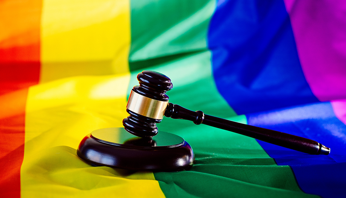 Martillo de madera sobre una bandera con los colores del arco iris