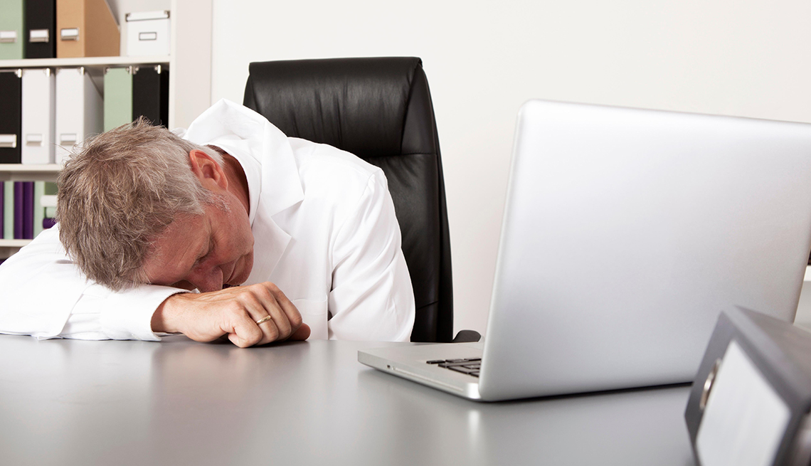 A man is sleeping at his desk during work