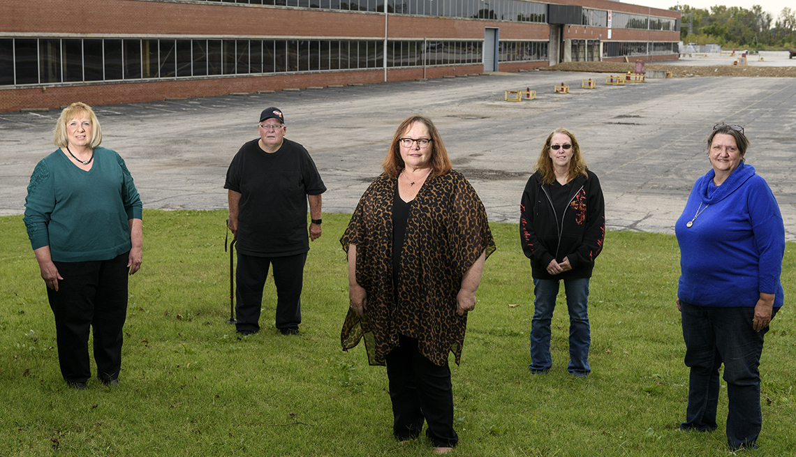 A group of people stand in front of an empty factory