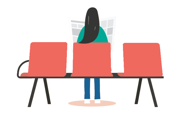 Woman sitting reading a newspaper at a bus stop