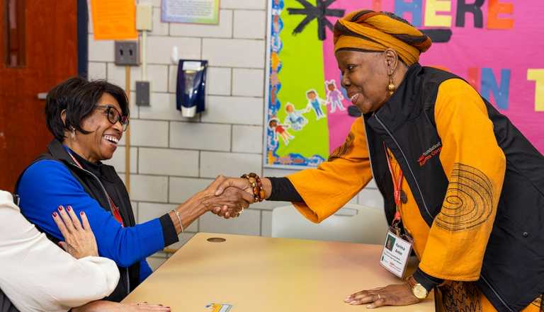 AARP Foundation Tutor, Elizabeth "Marie" Brooks shakes hands with Tutor, Karima Amin at Dr. Lydia T. Wright School of Excellence in Buffalo, NY.