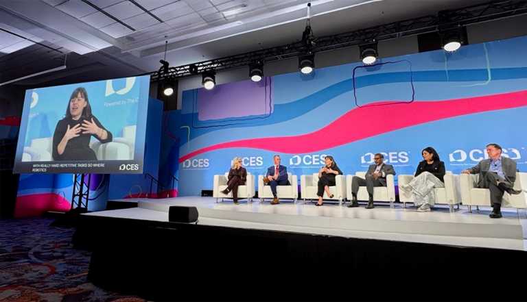 Claire at CES with panel of speakers