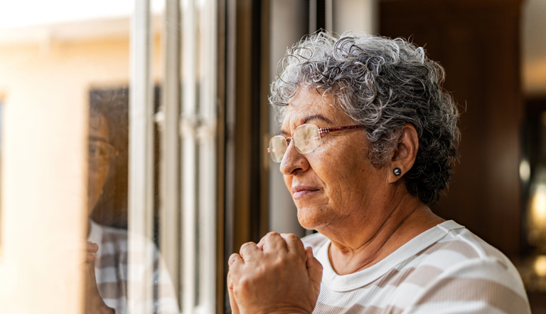 Senior woman looking out her window