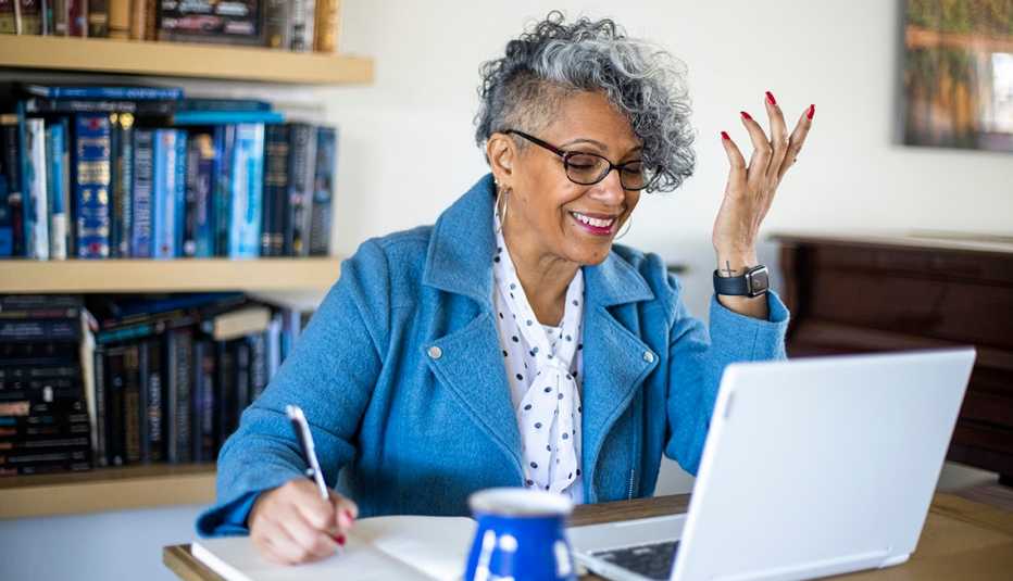 A beautiful mature black woman with gray hair working from home.