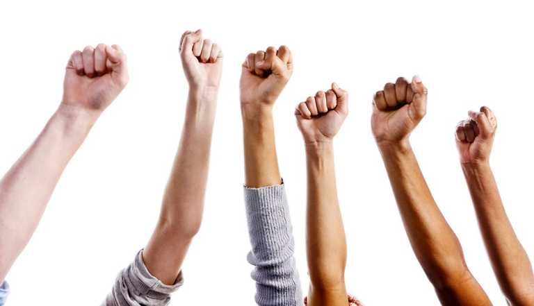 Multiracial clenched fists raised in the air could signify approval or defiance. Isolated against a white background. 