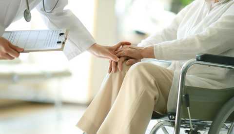 Doctor examining patient in wheelchair