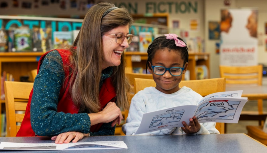 Experience Corps volunteer tutor, Pam Cuddihy, reading to student, Kadence McCall in Buffalo, New York.