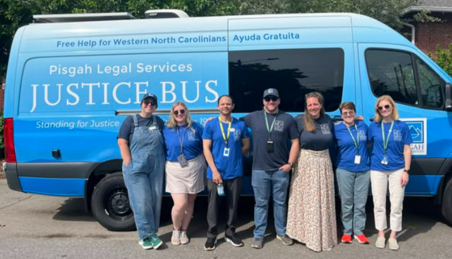 Pisgah Legal Services Justice blue bus with a group of people in front