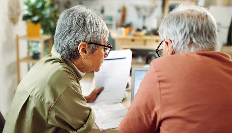 Senior woman and man sitting at a table reviewing papers