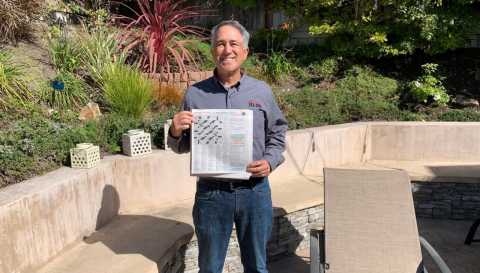 Caucasian older man wearing grey shirt and jeans in his backyard