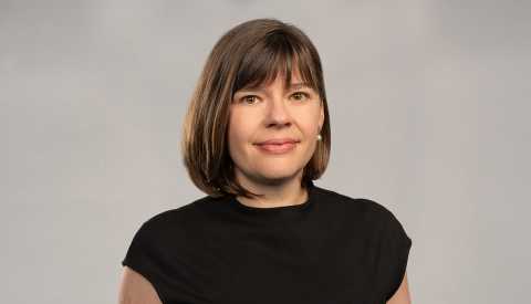 Photo of Claire Casey, woman with brown hair wearing a black dress