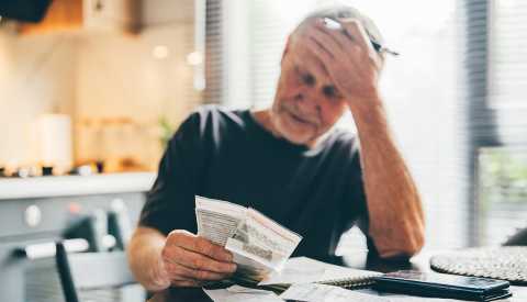 Man calculates monthly expenses check receipts to pay.