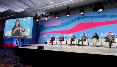 Claire at CES with panel of speakers