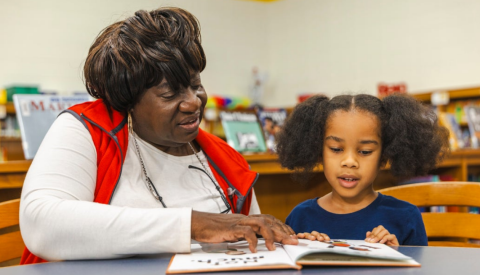 Woman reading to a child in a library